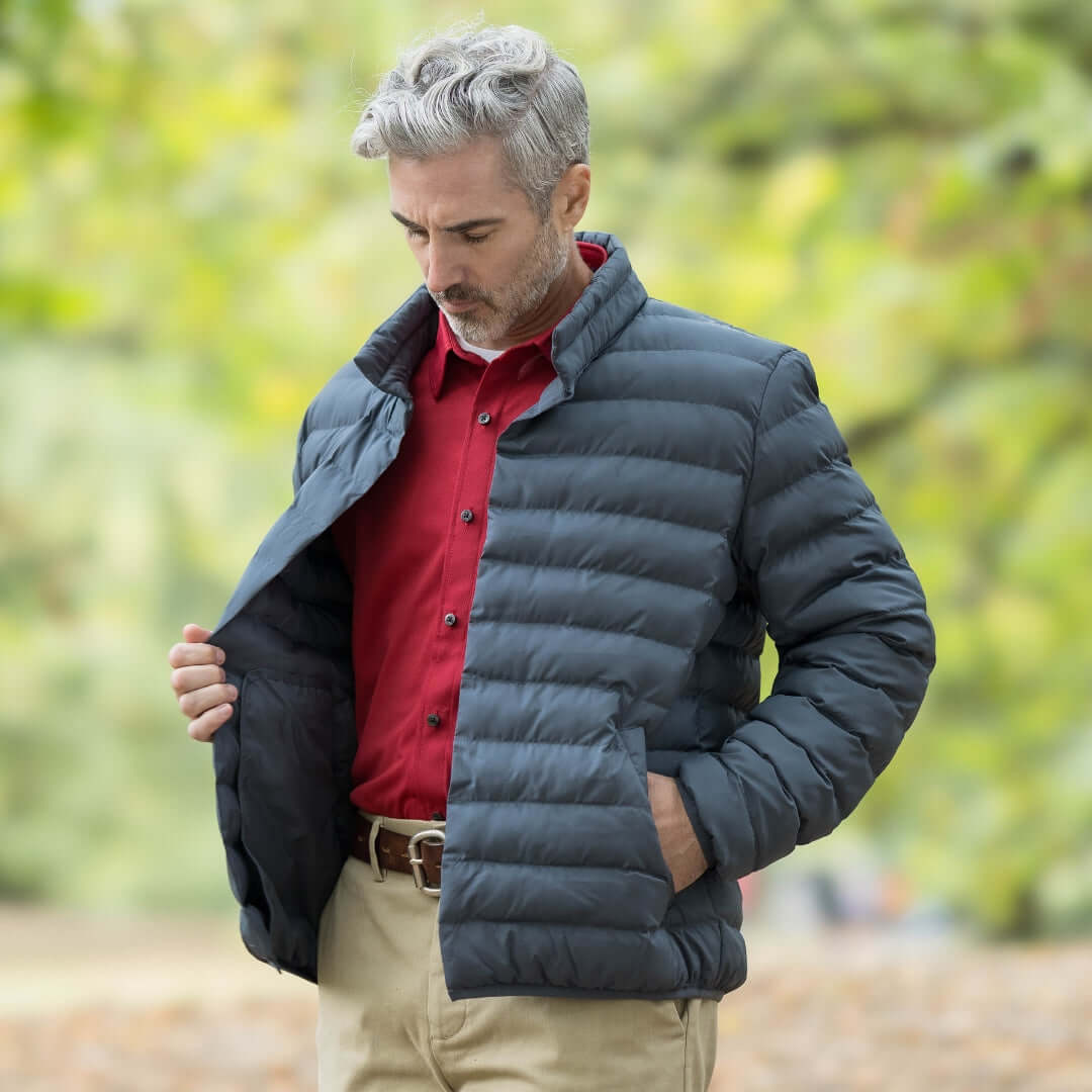 Man wearing Weatherproof x MagnaReady pewter puffer jacket outdoors, showcasing magnetic closure and stylish design.