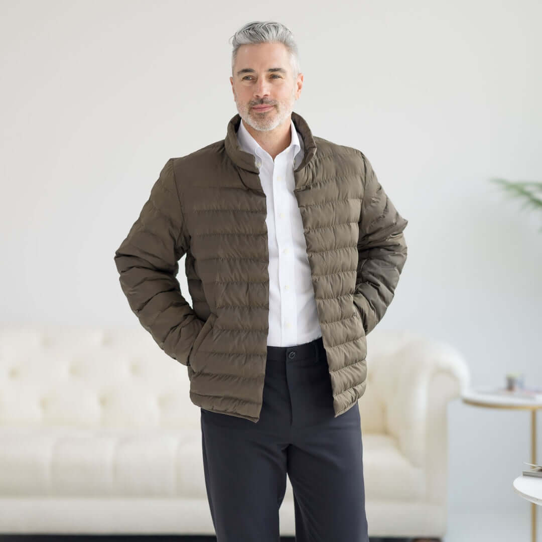 Olive Weatherproof x MagnaReady magnetic front puffer jacket worn by a man with gray hair in a stylish indoor setting.