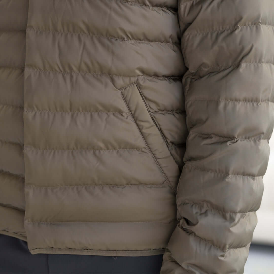 Close-up of the Weatherproof x MagnaReady olive puffer jacket showing magnetic closure and quilted design.