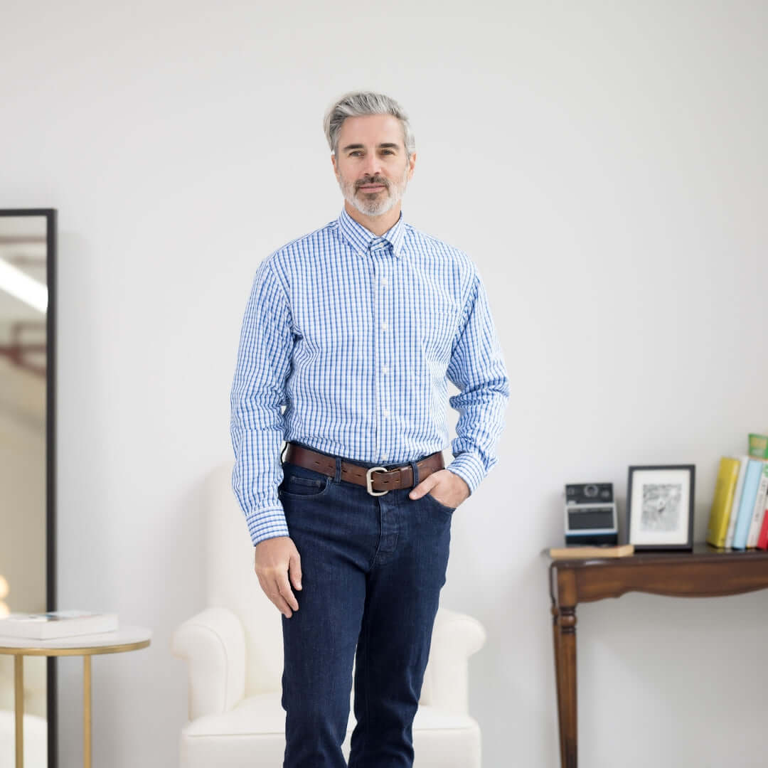 Man wearing a white and blue plaid long sleeve button-down collar shirt with magnetic closures.
