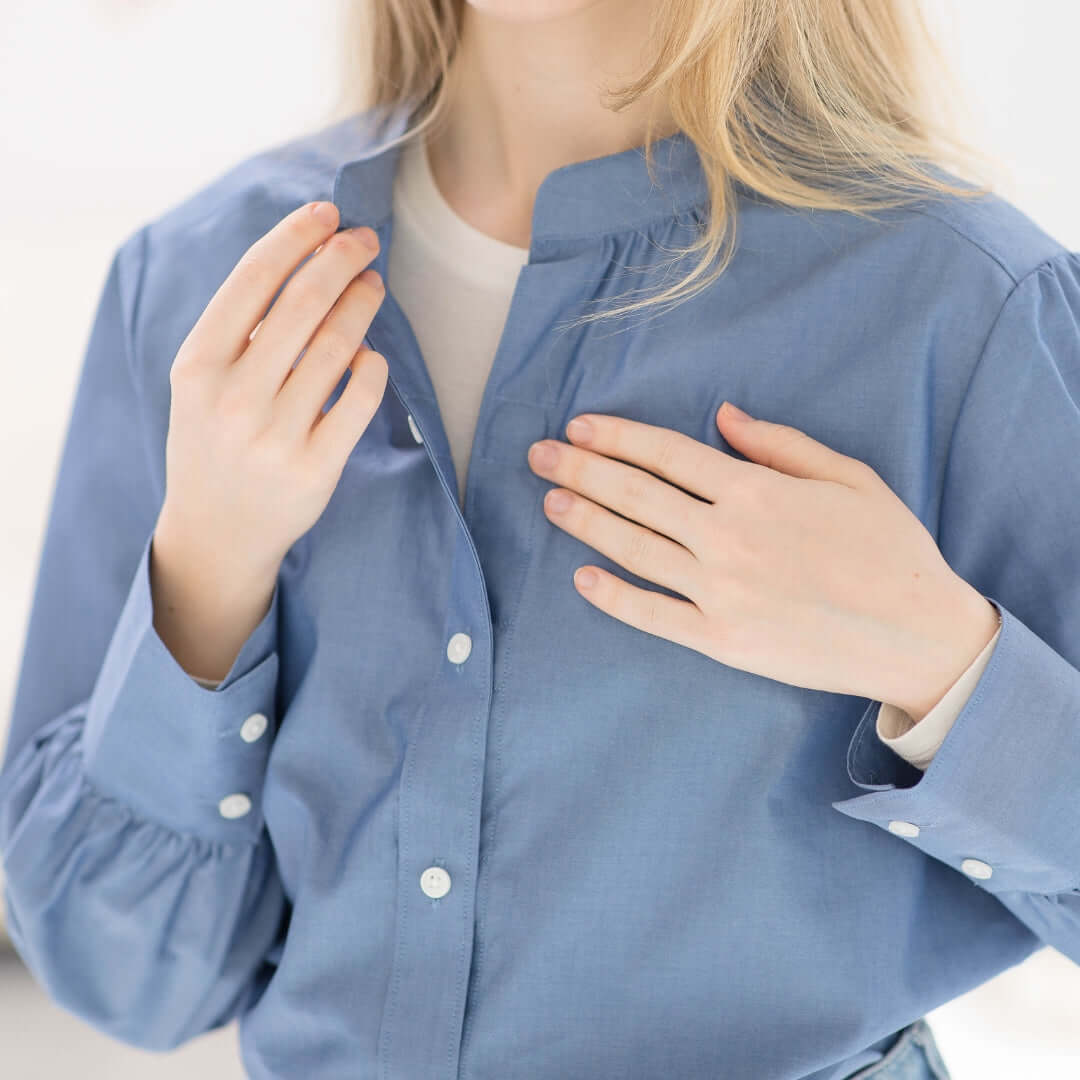 Woman wearing a MagnaReady Women's Adaptive Magnetic Chambray Blouse, showcasing its stylish design and innovative features.