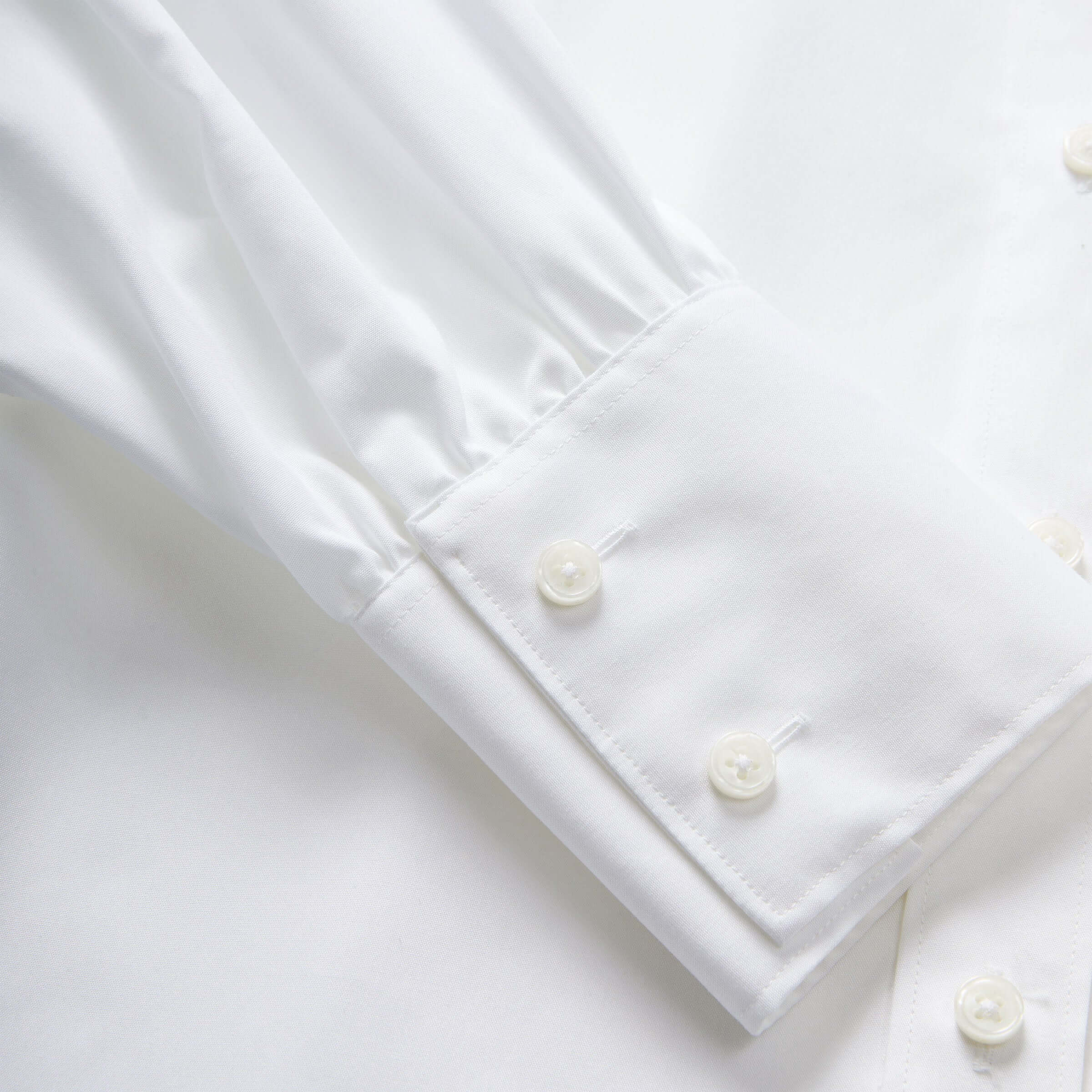 Close-up of the cuff of a Women's Adaptive Classic White Blouse, featuring buttons and soft fabric.