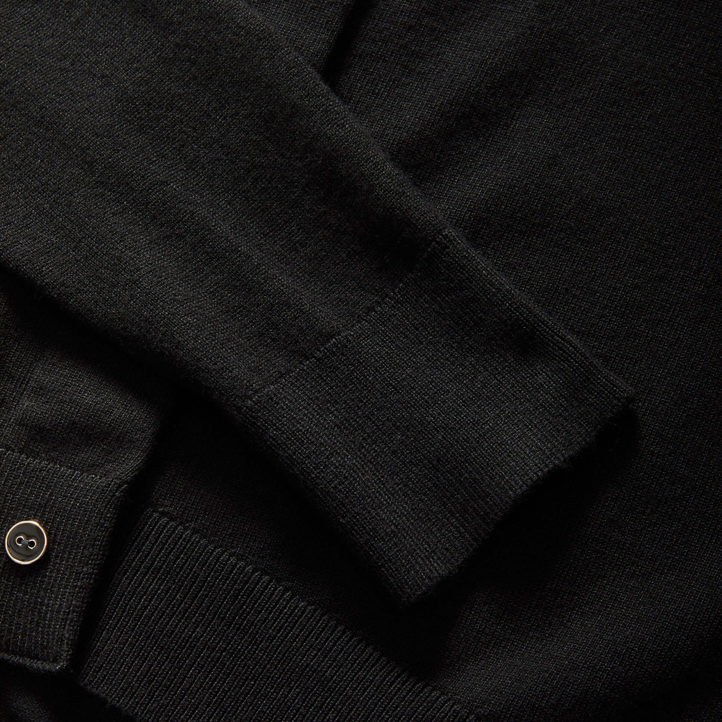 Close-up of a black women's adaptive cardigan sleeve featuring magnetic fasteners for easy dressing.