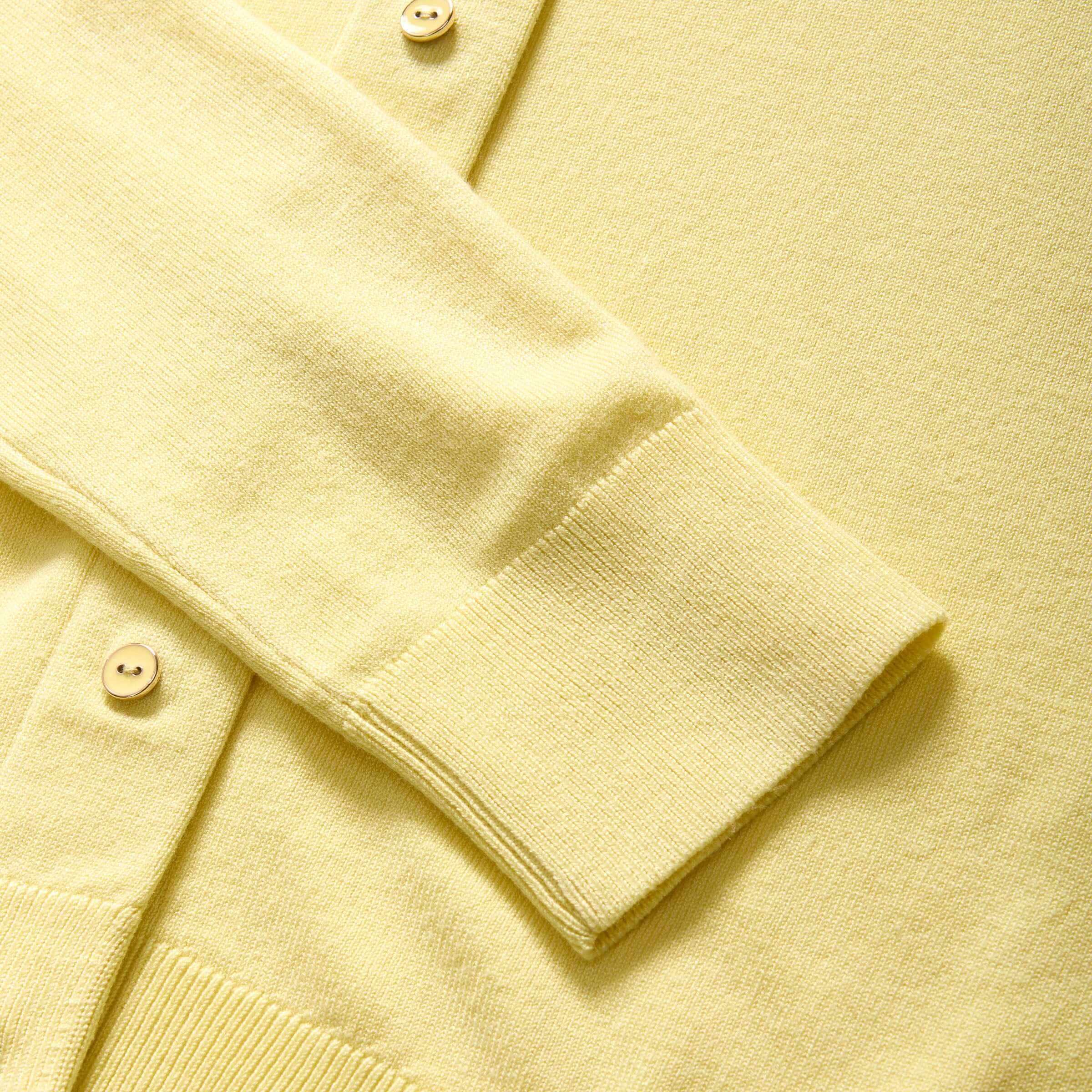 Close-up of a yellow women's adaptive cardigan sweater with buttons and a soft knit texture.
