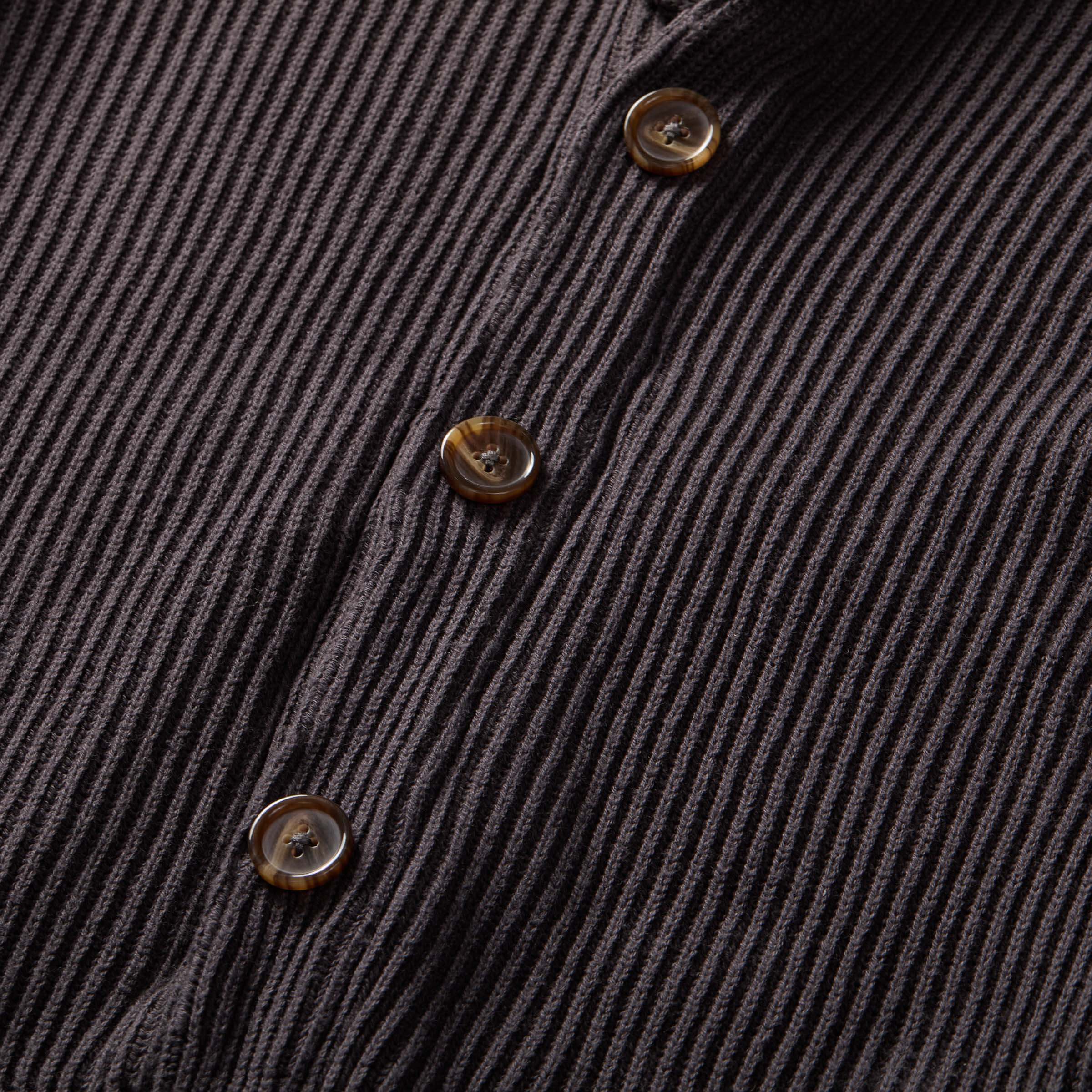 Close-up of charcoal ribbed cardigan buttons, showcasing magnetic button front and textured knit design.
