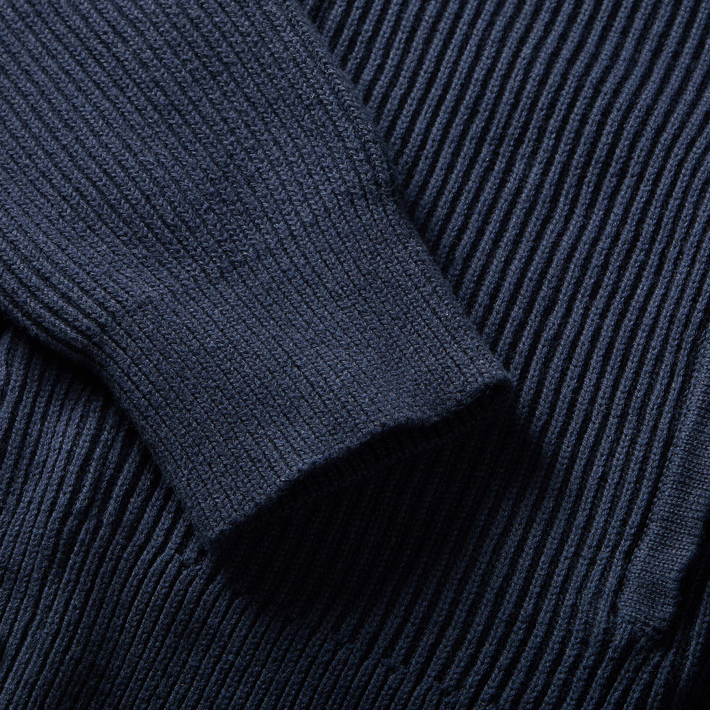 Close-up of navy ribbed cotton shawl collar cardigan sleeve showcasing texture and style.
