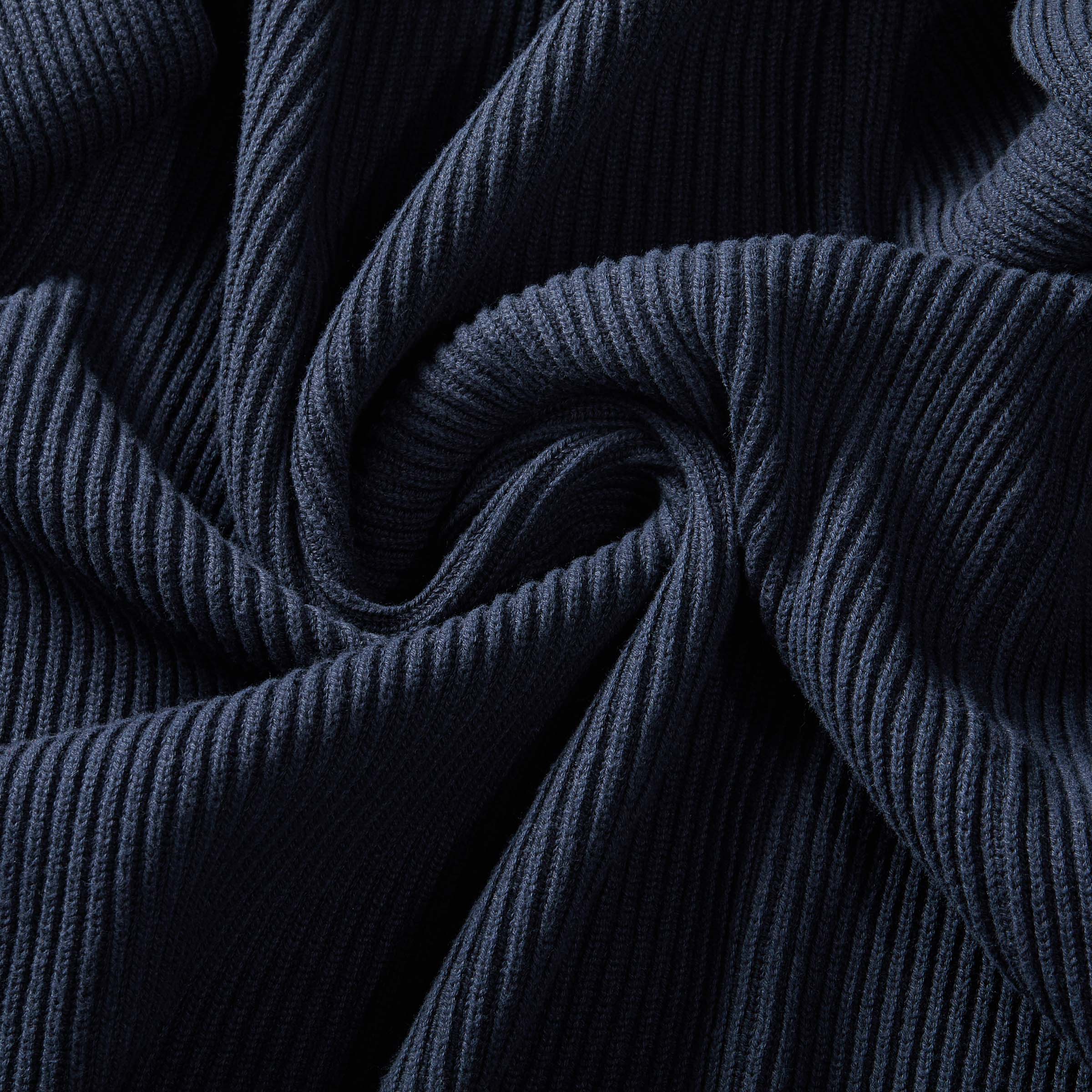 Close-up of navy ribbed cotton fabric showcasing texture and warmth of an adaptive cardigan.