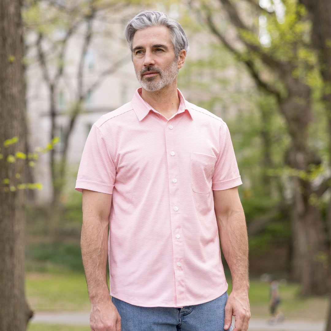 Adaptive Cooling Magnetic Front Short Sleeve Shirt in Coral Stripe worn by a man in a park setting.