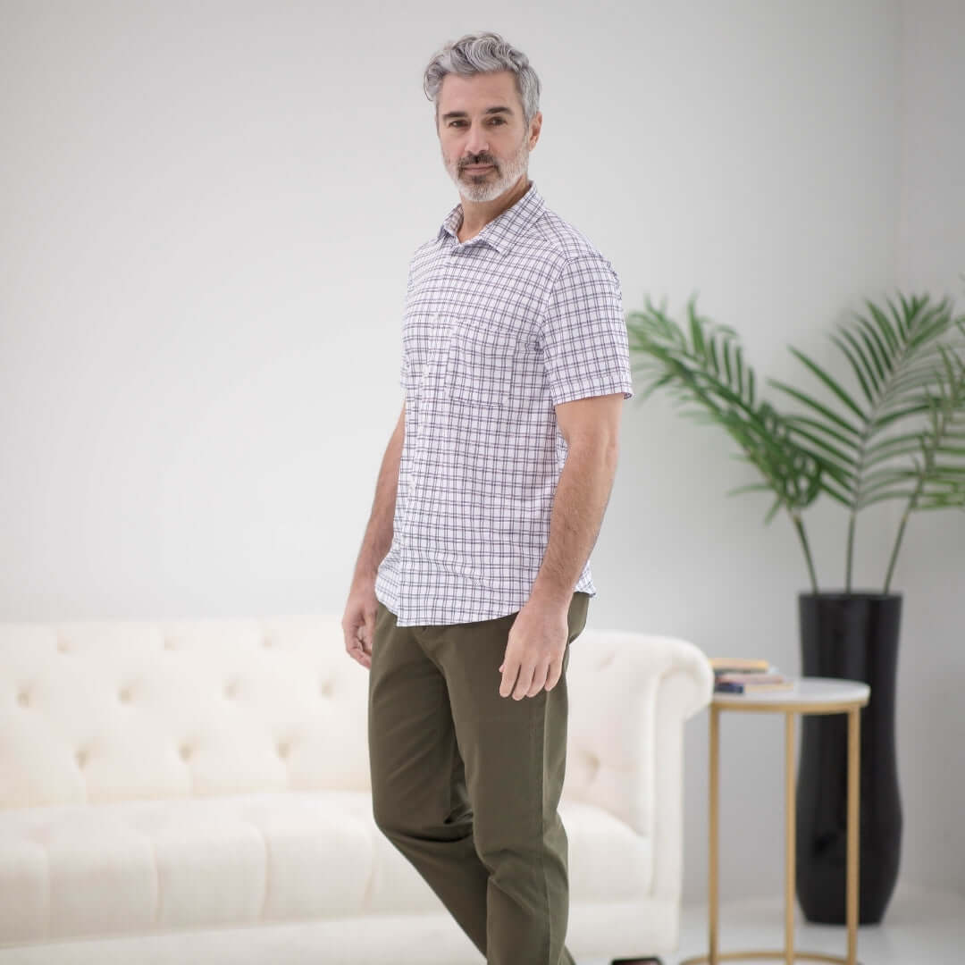 Man wearing adaptive cooling magnetic front short sleeves shirt in black and white grid design, promoting comfort and independence.