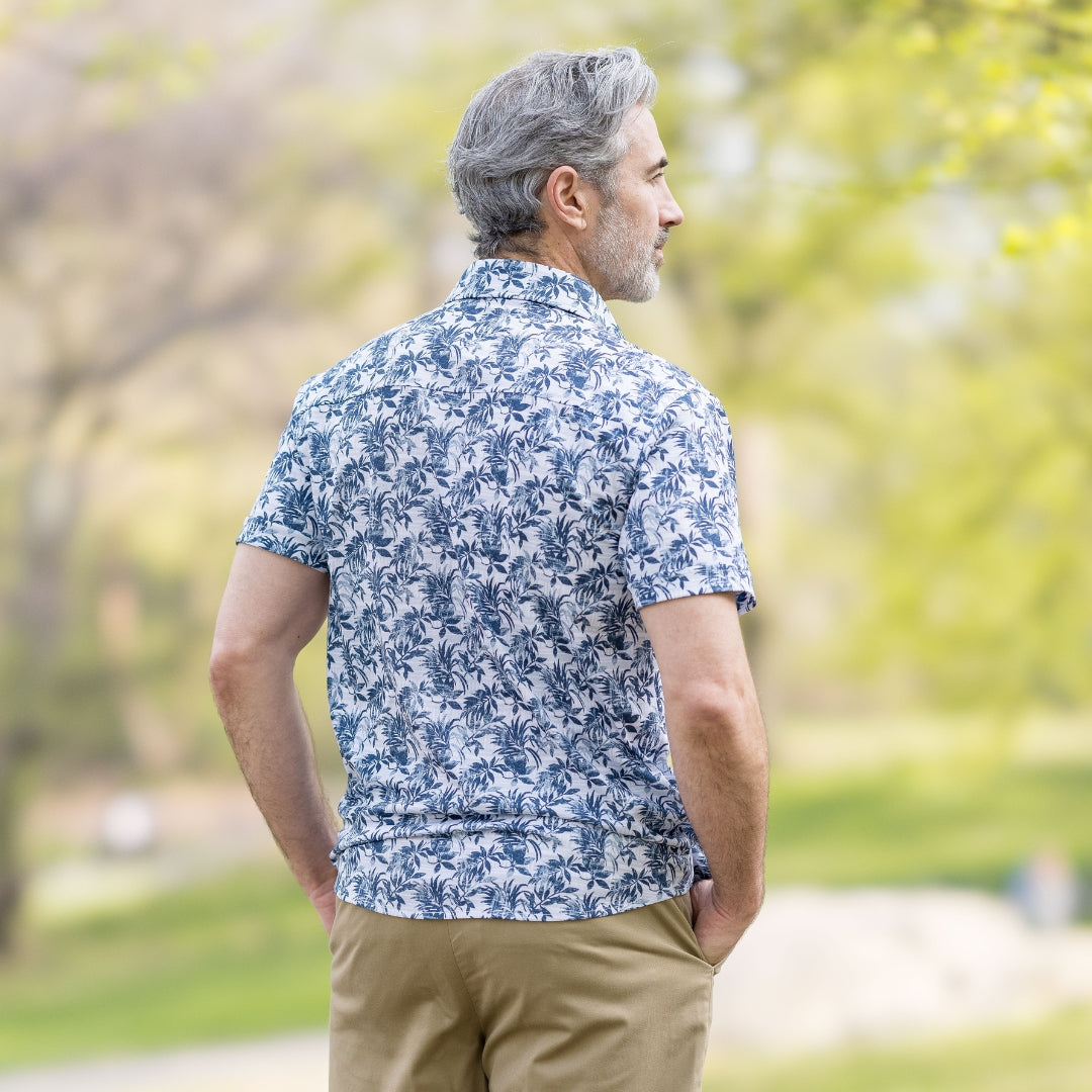 Adaptive Cooling Magnetic Front Short Sleeve Shirt in Blue Grey Palm worn by a man in a park.