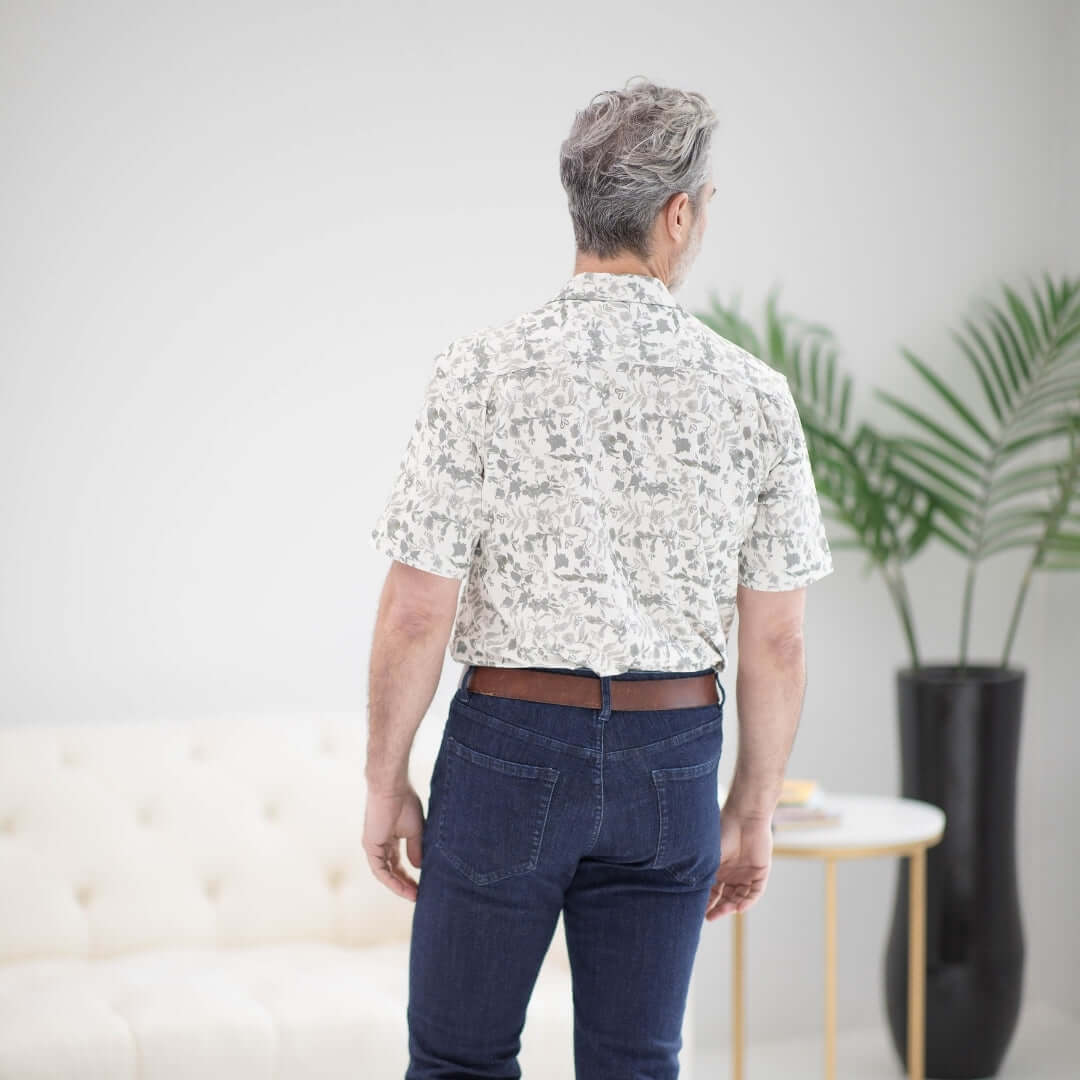 Man wearing a grey floral untucked short sleeve cooling shirt, showcasing its adaptive design from the back.