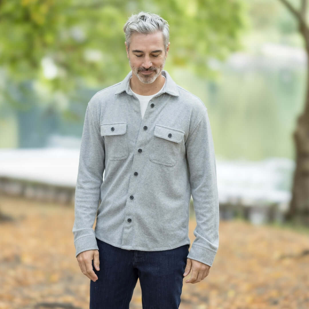 Man wearing an adaptive grey flannel shirt with pockets, styled for a casual autumn outdoor setting.