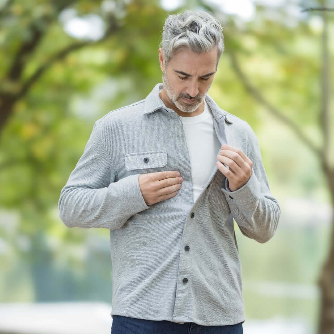 Man in adaptive grey flannel shirt with magnetic closures, enjoying the outdoors in a stylish and versatile layering piece.