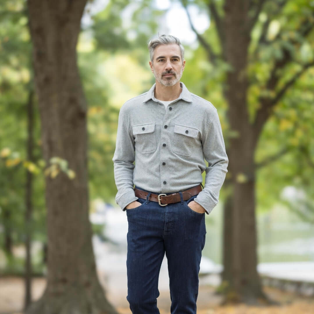 Man wearing an adaptive grey flannel shirt in a park, showcasing a stylish and versatile layering piece.