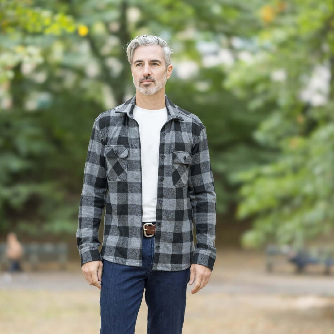 Man wearing a black buffalo check flannel shirt combo outdoors, perfect for layering in changing seasons.