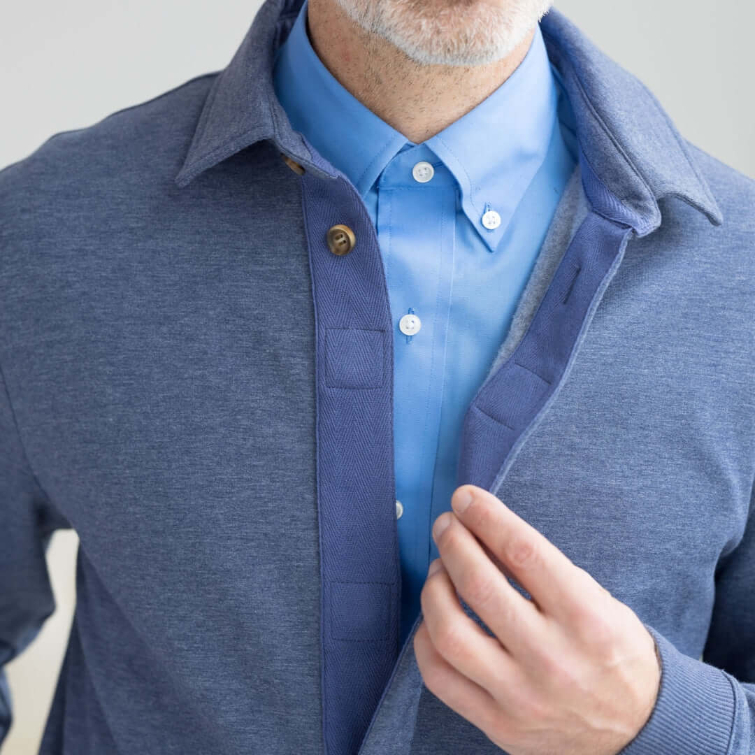 Close-up of a man wearing the Adaptive Magnetic Front Sweatshirt in Heathered Navy, featuring a blue collared shirt.