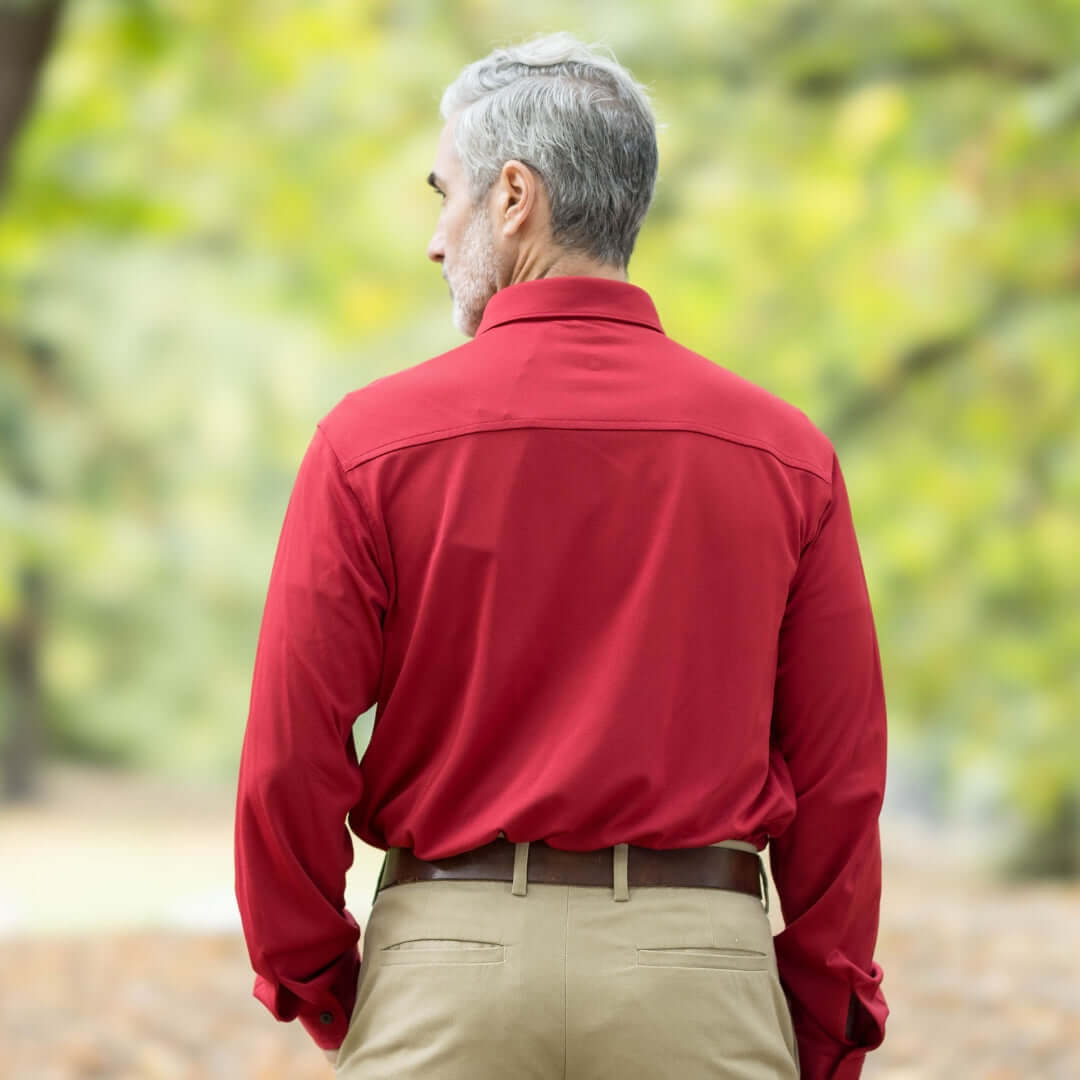 Rear view of man wearing adaptive Rio Red long sleeve cooling tech polo shirt outdoors.