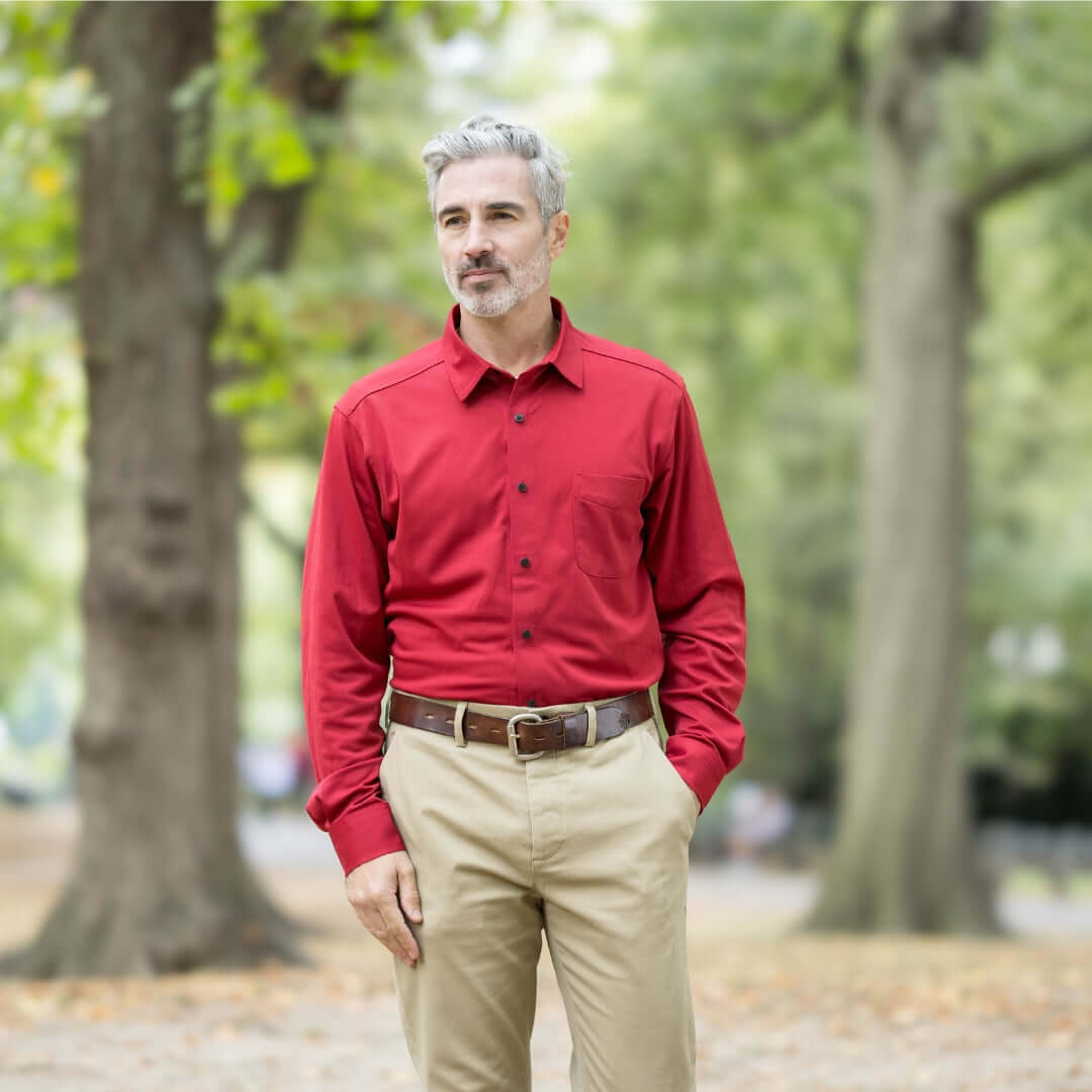 Man wearing a Rio Red long sleeve polo with magnetic buttons, standing outdoors in a park.