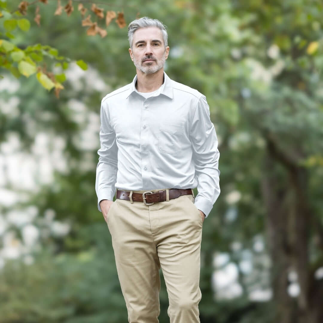 Adaptive White Magnetic Front Long Sleeve Cooling Adaptive Polo with Pocket worn by a man in a natural setting.