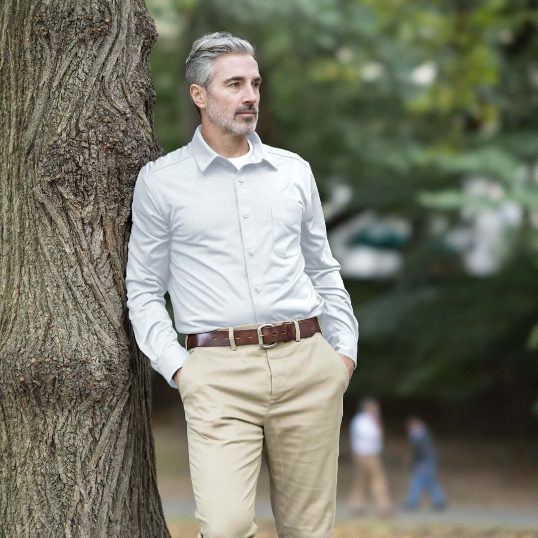Adaptive White Magnetic Front Long Sleeve Cooling Adaptive Polo with Pocket worn by a man in a natural outdoor setting.