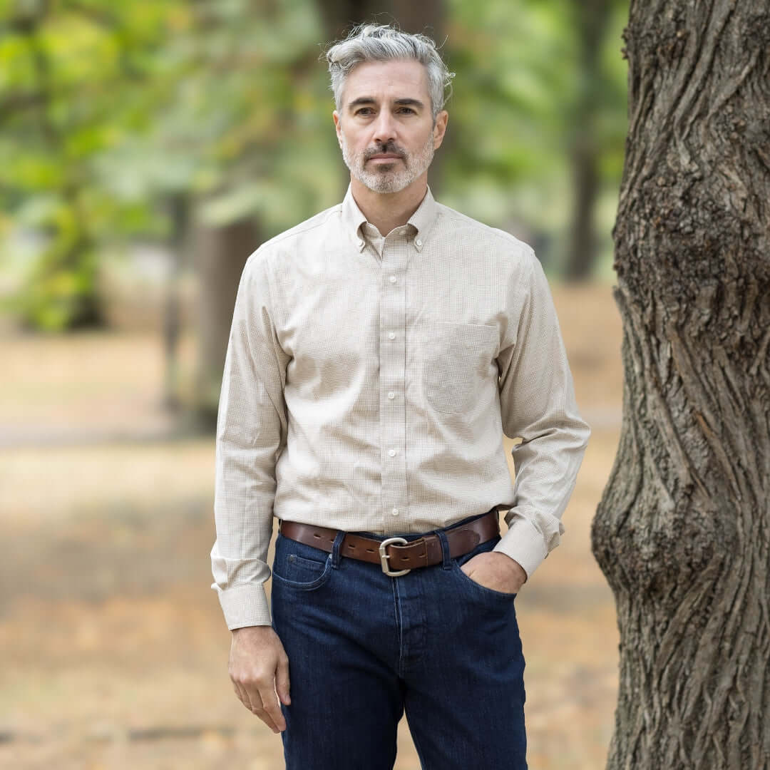 Man wearing a beige check long sleeve button-down collar shirt outdoors, showcasing adaptive fashion.