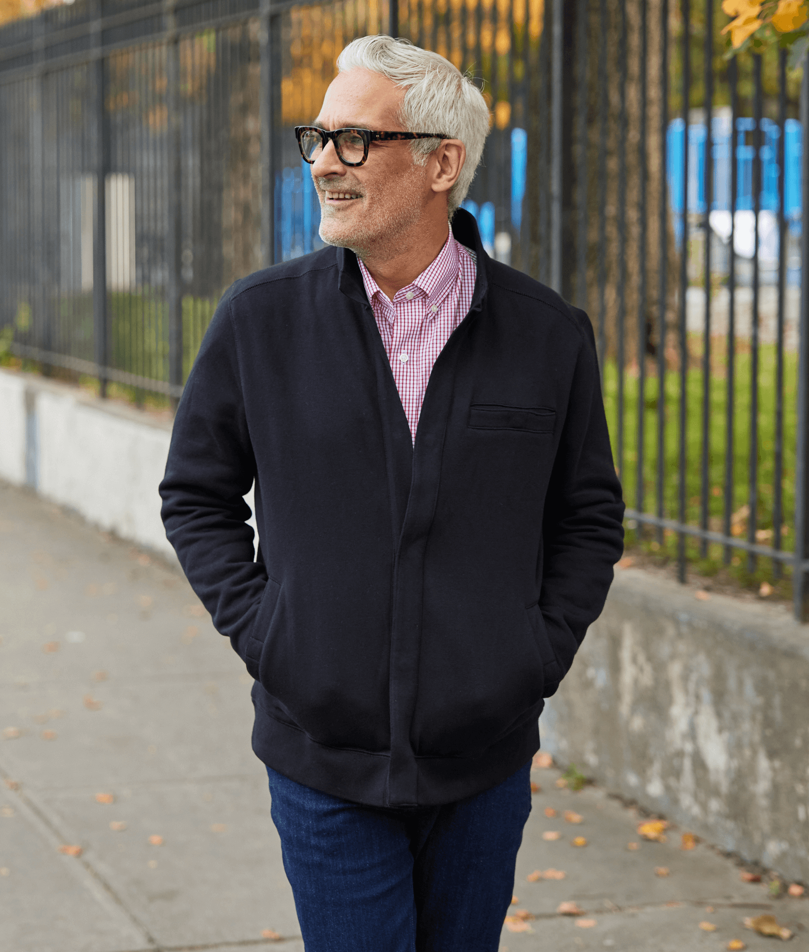 Man smiling outdoors in a black knit fleece Dillon jacket with magnetic closures, perfect for stylish comfort.
