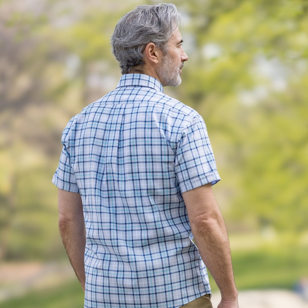 Man wearing a Blue Plaid Short Sleeve Shirt with Magnetic Closures, showing the back view in an outdoor setting.