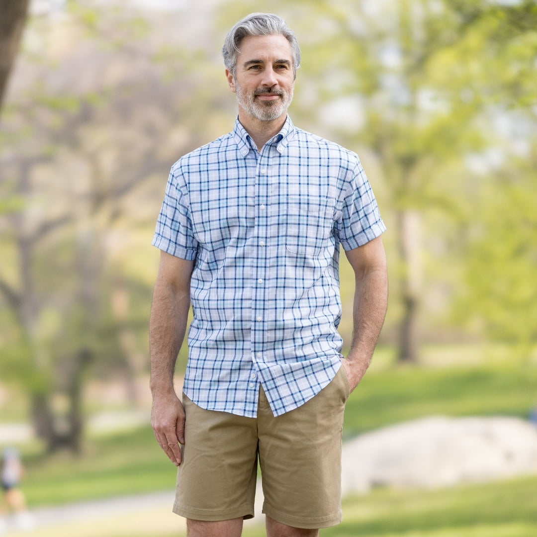 Blue Plaid Short Sleeve Shirt with Magnetic Closures worn by a man in a park with shorts.