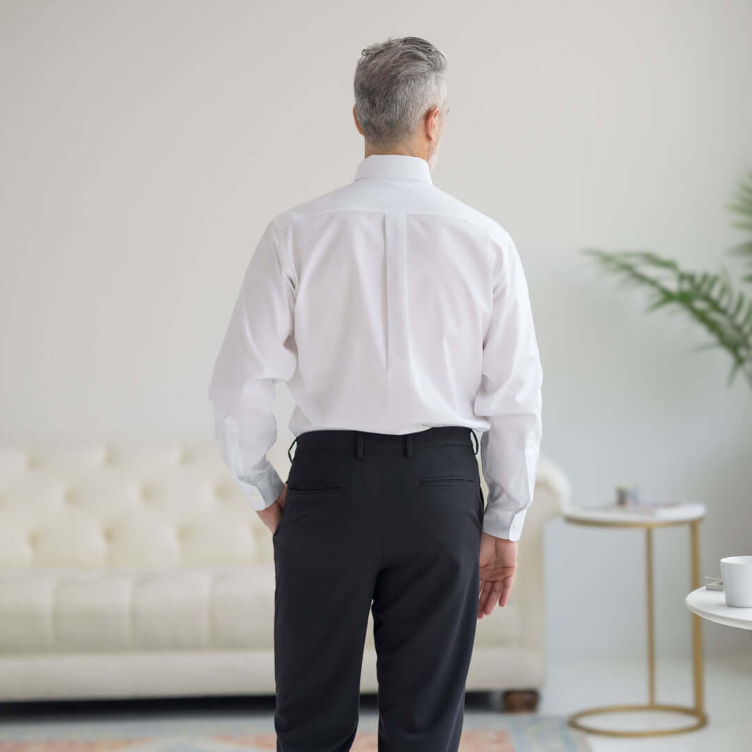 Back view of a man wearing a white Brooks Brothers x MagnaReady long sleeve polo with a button-down collar.