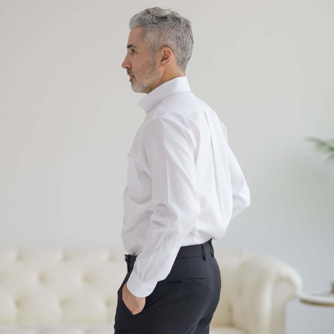 Side view of a man wearing a Brooks Brothers x MagnaReady white polo with button-down collar, showcasing comfort and style.
