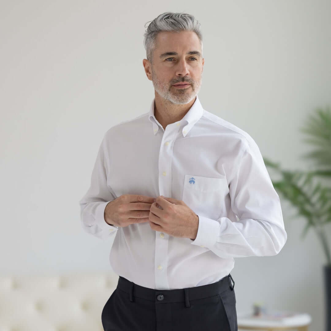 Brooks Brothers x MagnaReady white polo button-down shirt with magnetic closures, modeled by a stylish man.