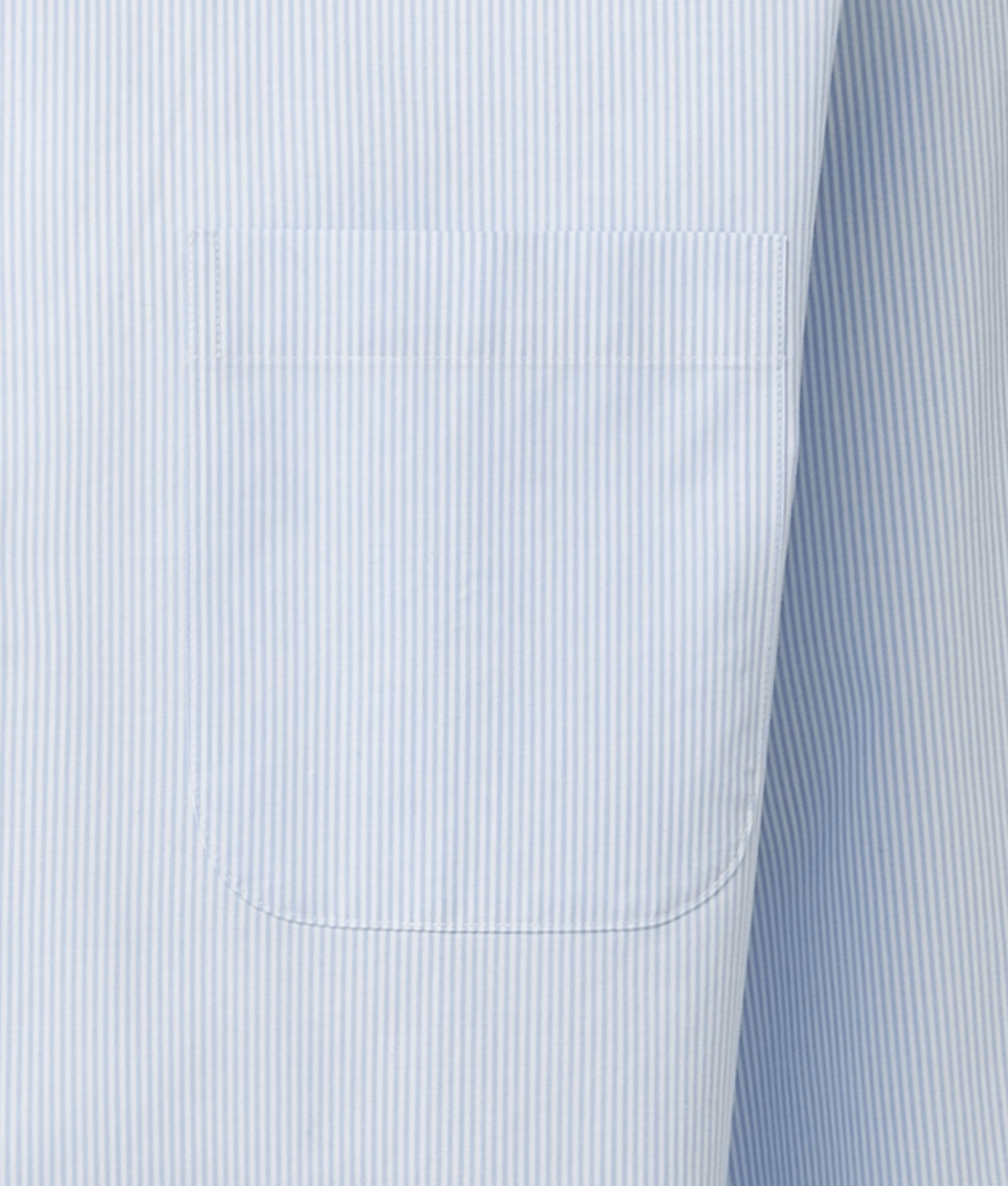 Close-up of Brooks Brothers blue and white striped polo shirt showing the pocket detail with adaptive technology.