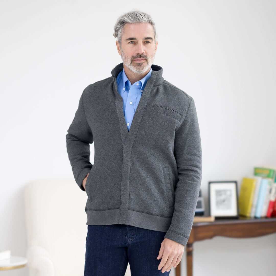 Stylish middle-aged man wearing a gray sweater and blue shirt, posing confidently indoors.
