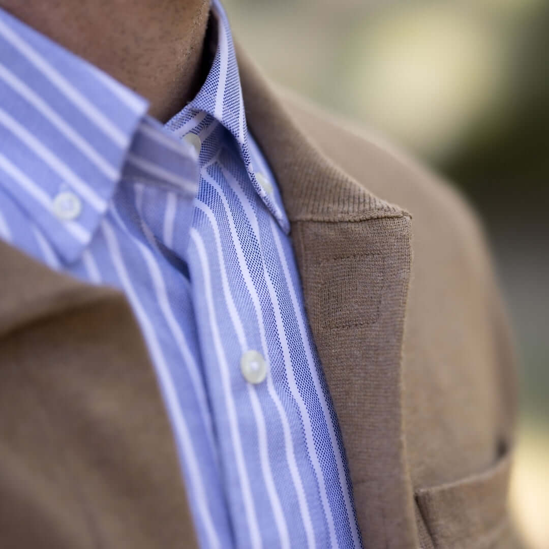 Classic Adaptive Sweater with Magnetic Front Closure and Pocket worn over a striped shirt.