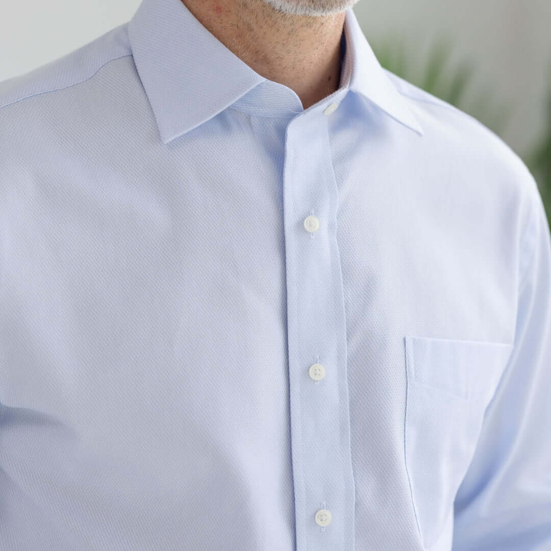 Close-up of light blue 'Ryan' dress shirt featuring a spread collar and button details for adaptive clothing.
