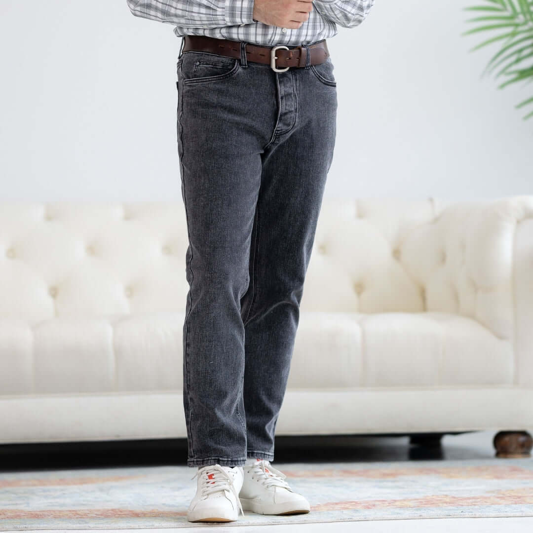 Man wearing black wash five pocket jeans with magnetic fly, styled with a belt and casual shoes.