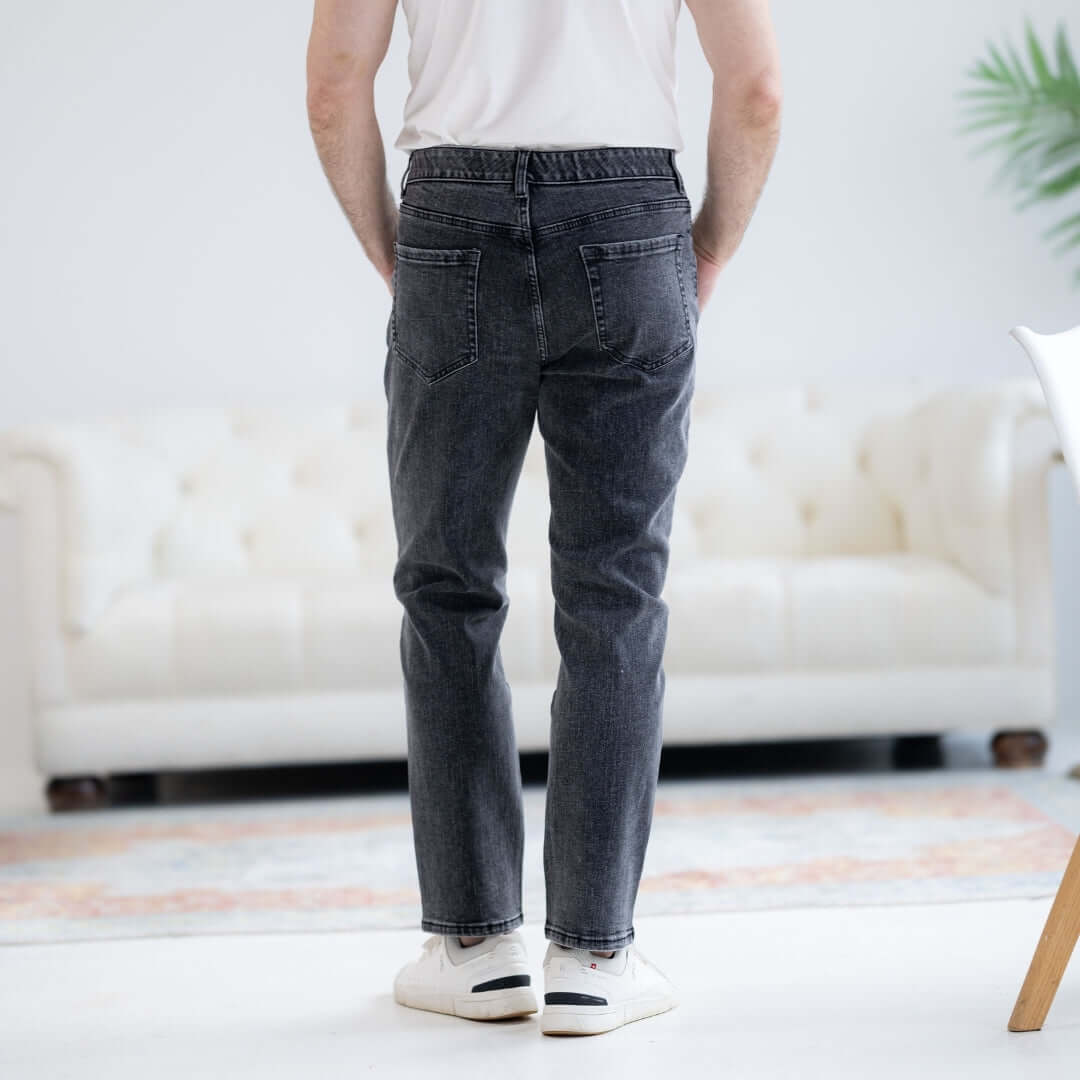 Man wearing black wash adaptive five pocket jeans with magnetic fly, ideal for limited mobility, seen from the back.