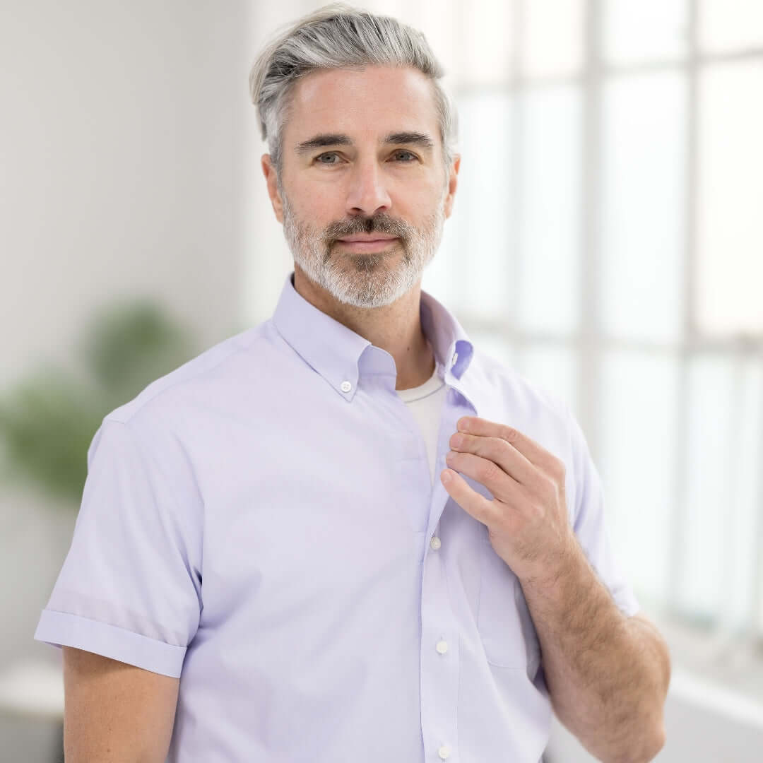 Model wearing a lavender short sleeve button-down collar shirt with magnetic closures, exuding classic style.