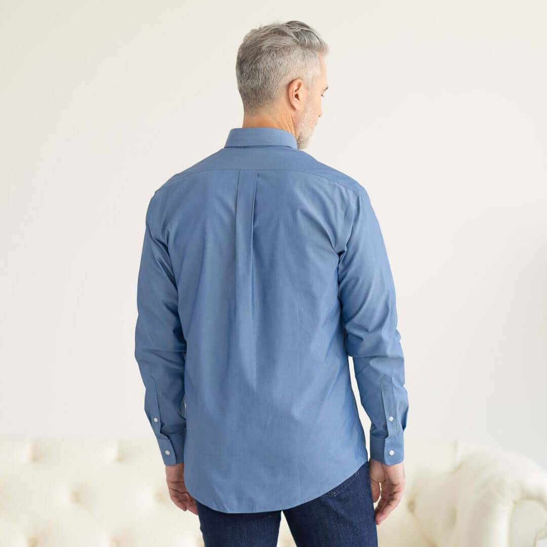 Back view of a man wearing a long sleeve blue chambray shirt with magnetic closures, showcasing adaptive fashion design.