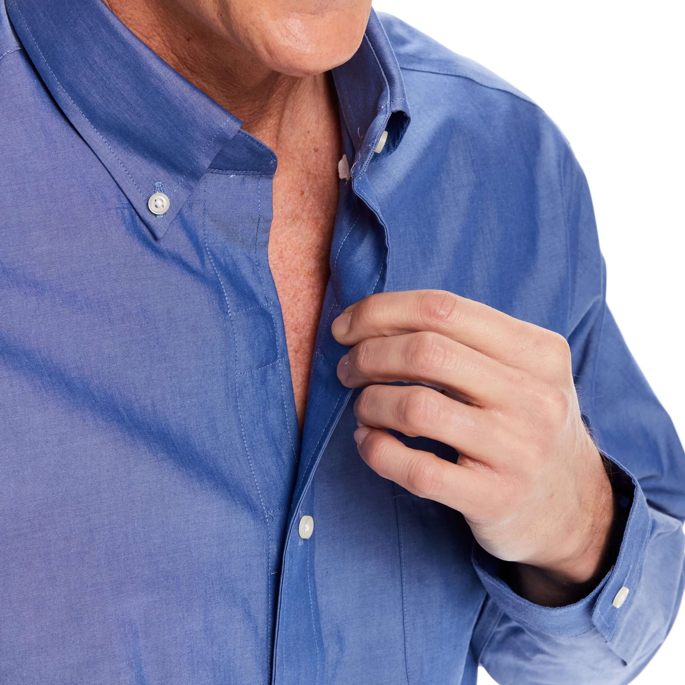 Close-up of a man in a blue chambray shirt with magnetic closures, demonstrating easy dressing.
