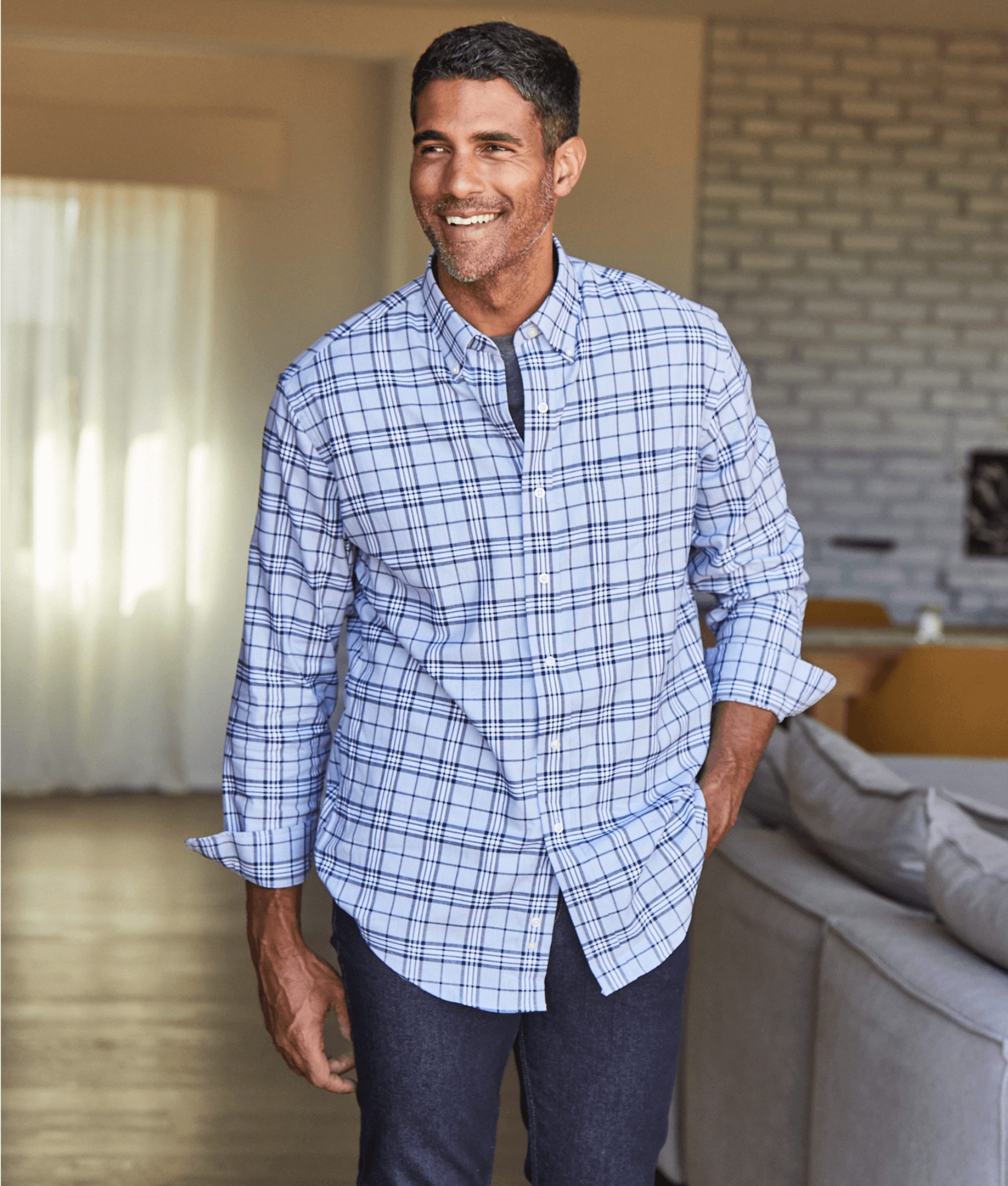 Smiling man in a long sleeve sky blue plaid shirt, showcasing MagnaReady® adaptive menswear style.
