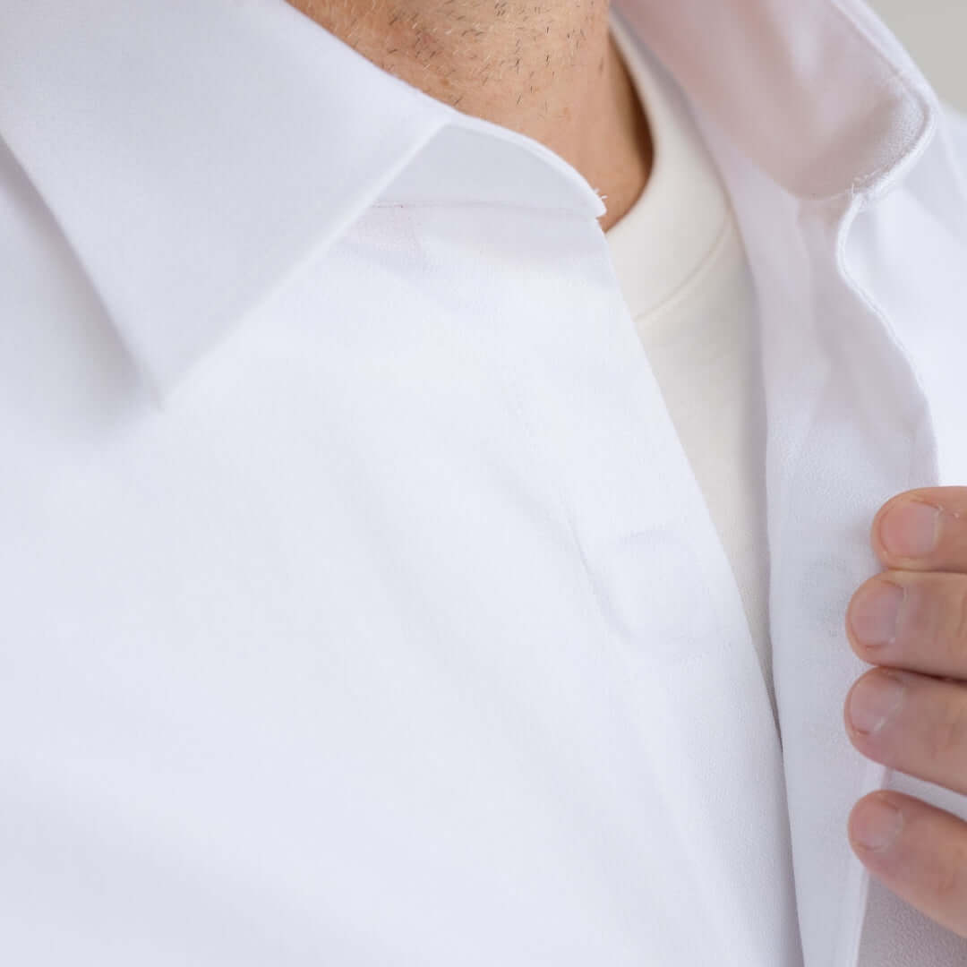 Close-up of a man's neck and collar of a white dress shirt featuring a spread collar design.