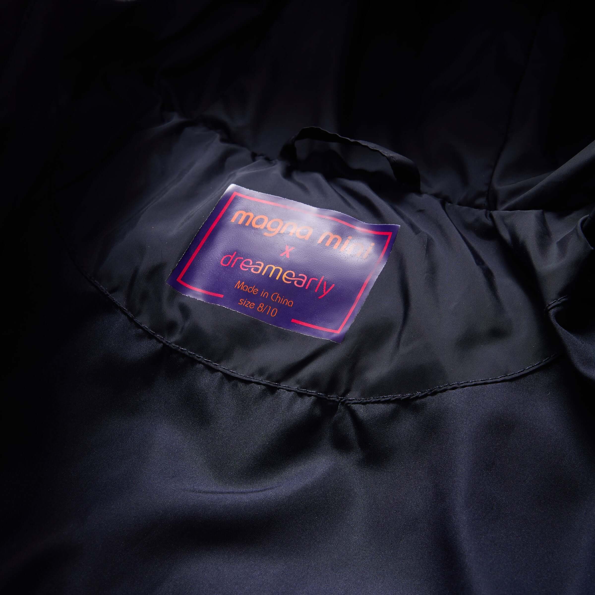 MagnaMini Kids puffer coat interior label showing size 8/10 and branding details.