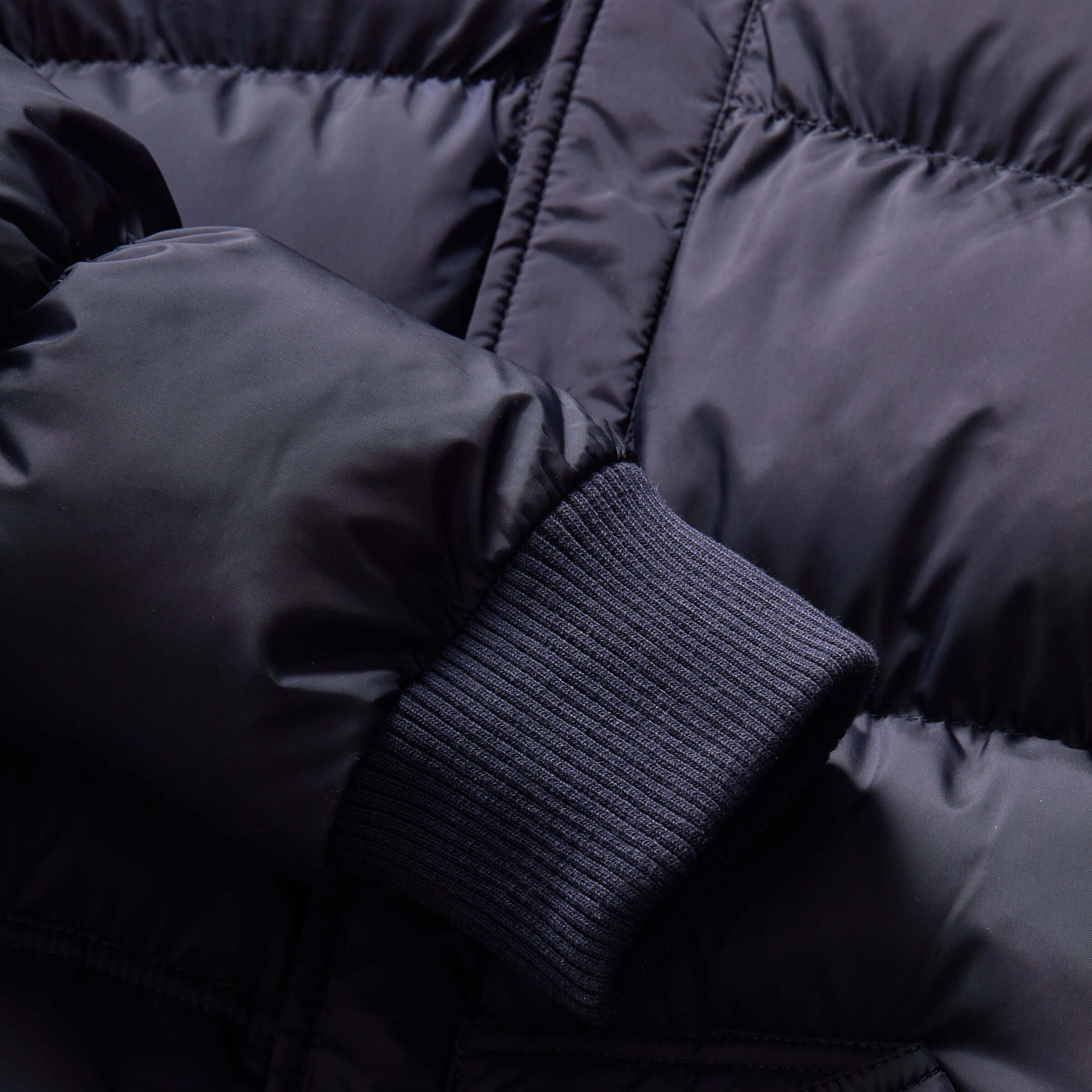 Close-up of the navy MagnaMini kids puffer coat sleeve detail featuring a ribbed cuff.