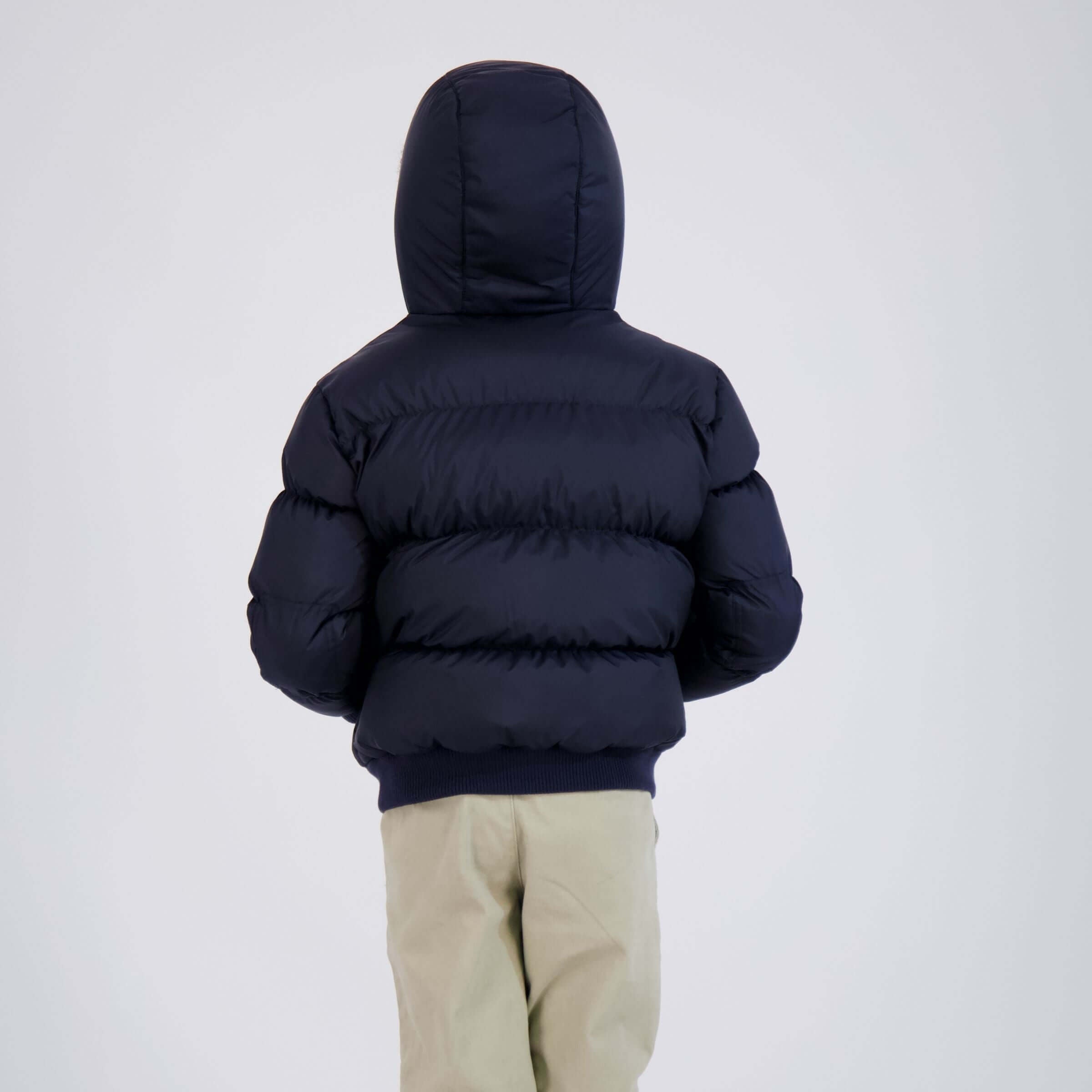 Back view of a child wearing a navy MagnaMini kids magnetic puffer coat with hood.