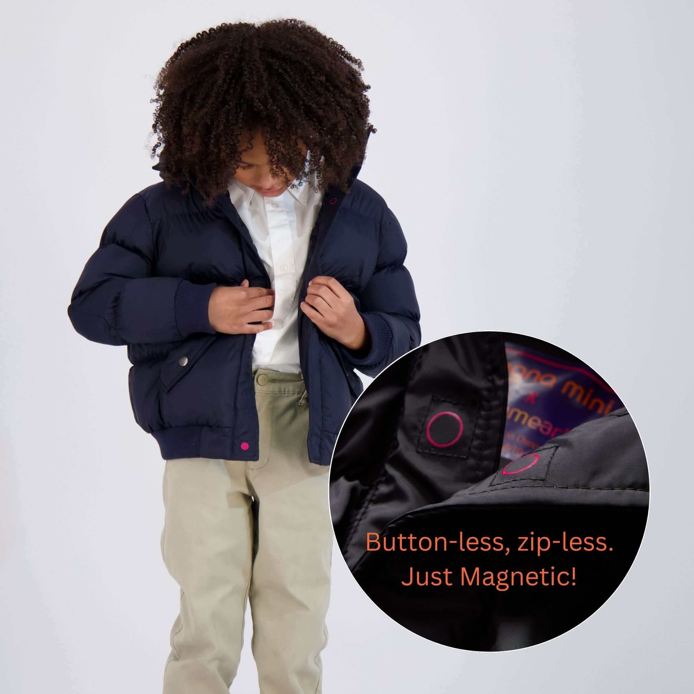 Child wearing a navy MagnaMini magnetic puffer coat, showcasing its button-less, zip-less design for easy dressing.