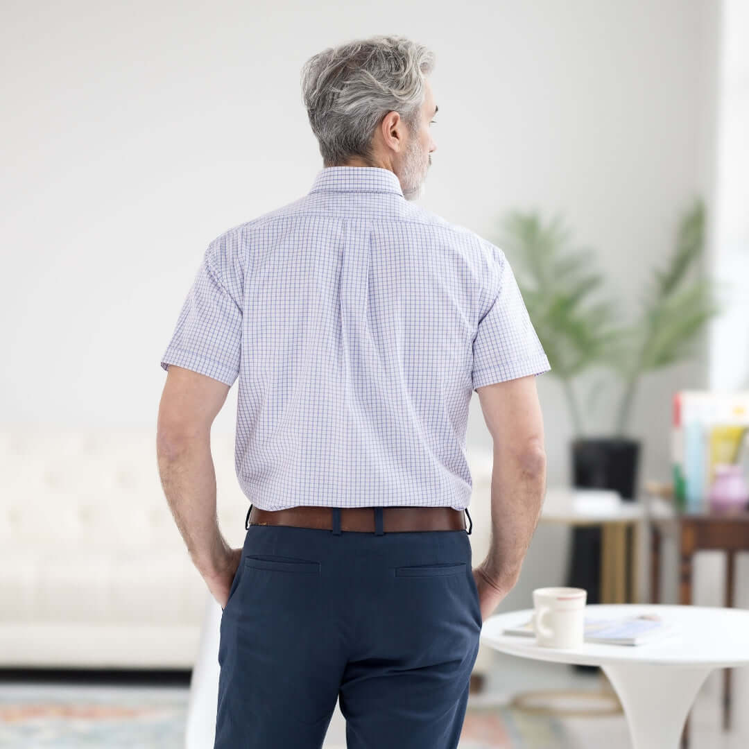 Back view of a man wearing a short sleeve red, white, and blue button-down collar shirt with magnetic closures.