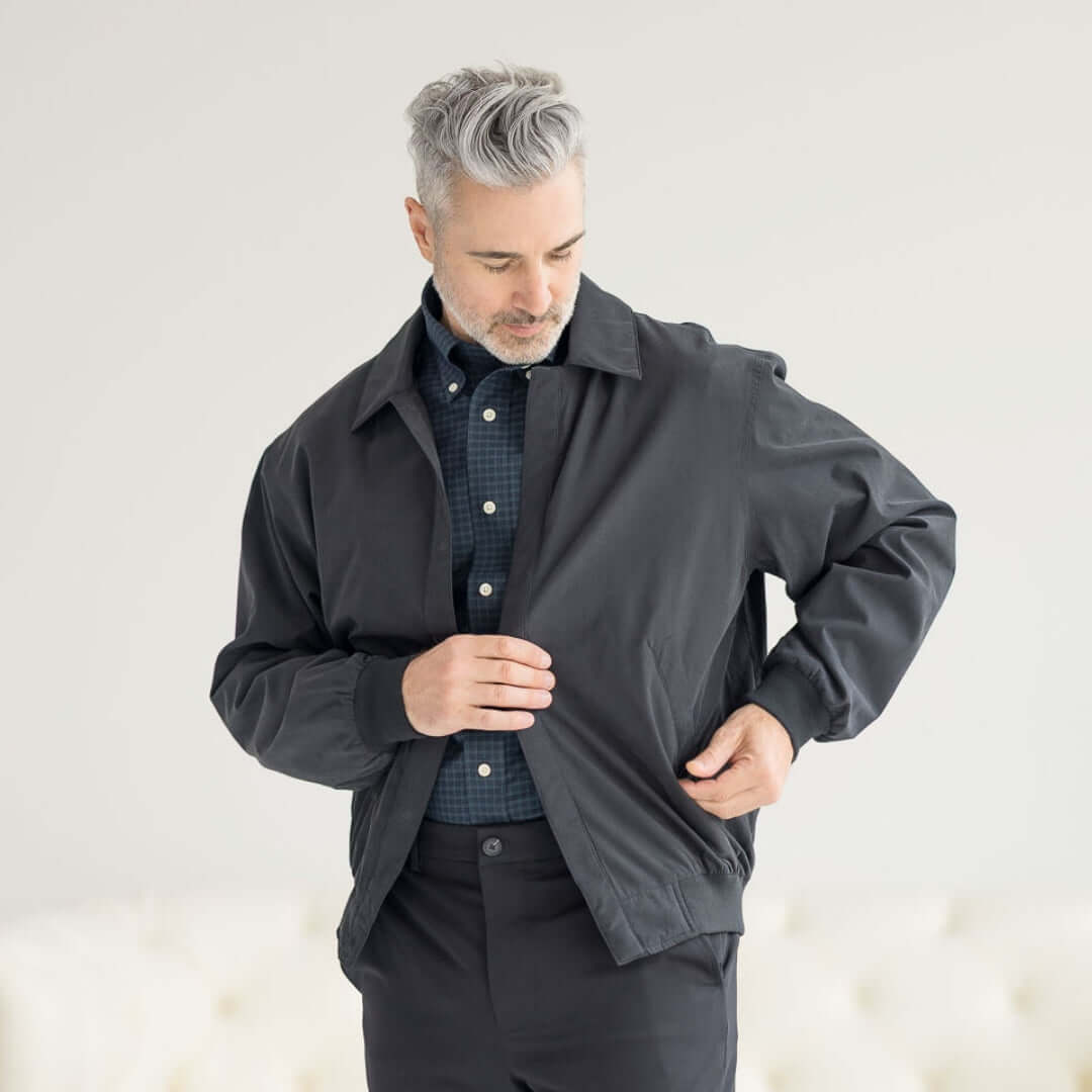Man wearing MagnaReady® X Weatherproof Black Golf Jacket, showcasing its adaptive and stylish design for easy wear.