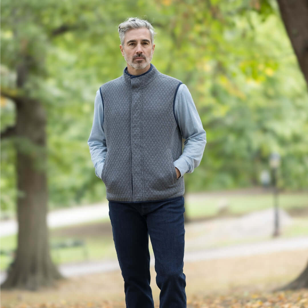 Man wearing a charcoal MagnaReady® Reversible Diamond Quilted Magnetic Button Vest in a park setting.