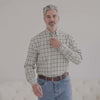 Man wearing a green and black plaid long sleeve button-down shirt with magnetic closures, designed for easier dressing.